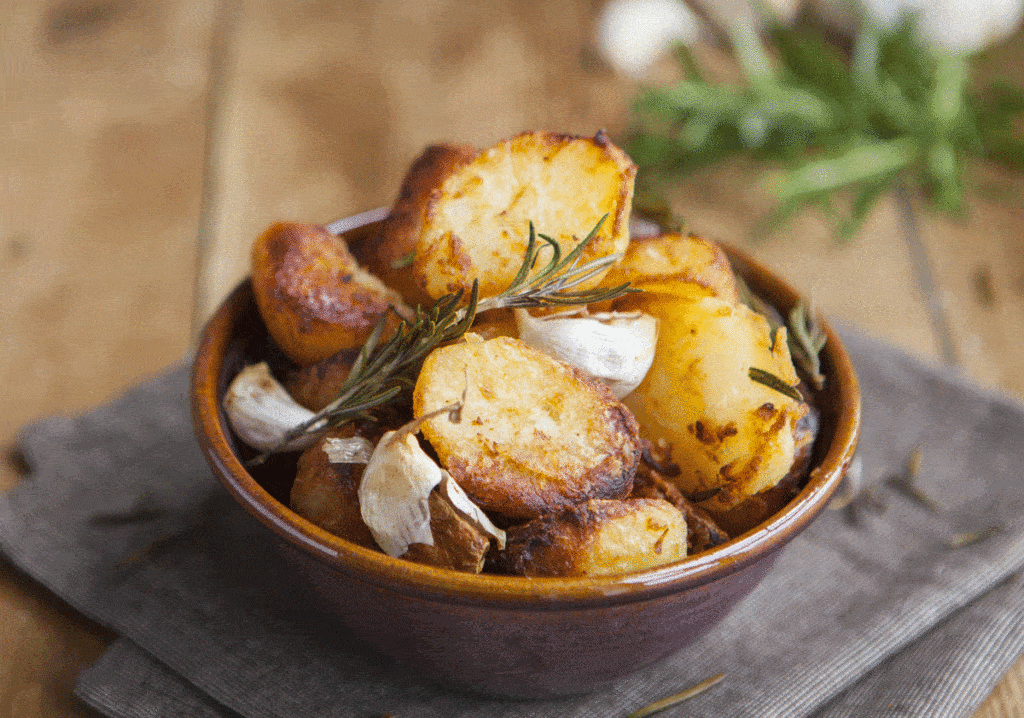 Roast potatoes in bowl with garlic and rosemary